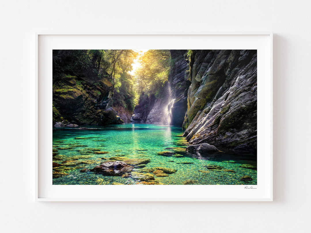 Turquoise water and sunlit forest in Burke River Gorge, displayed in a white frame with a white mat.
