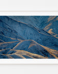 Light and shadow across the rolling hills of Lindis Pass, displayed in a white frame with a white mat.