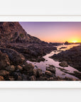 Rocky coastline at Whiterea Park at sunset, displayed in a white frame with a white mat.